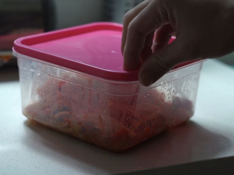 osoba pakuje hranu u plastičnu posudu